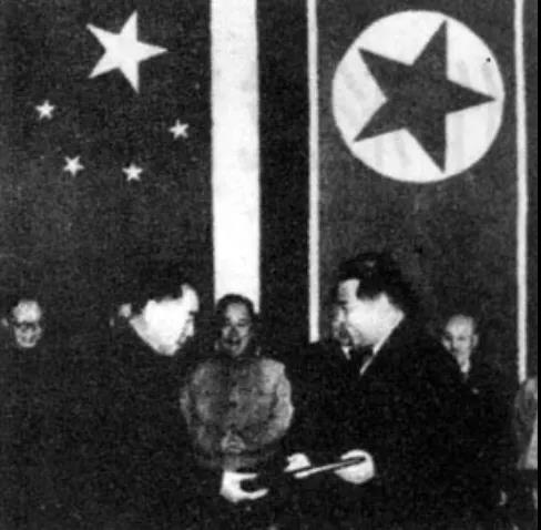 △周恩來(lái)和金日成在簽字后互換議定書(shū)。.jpg